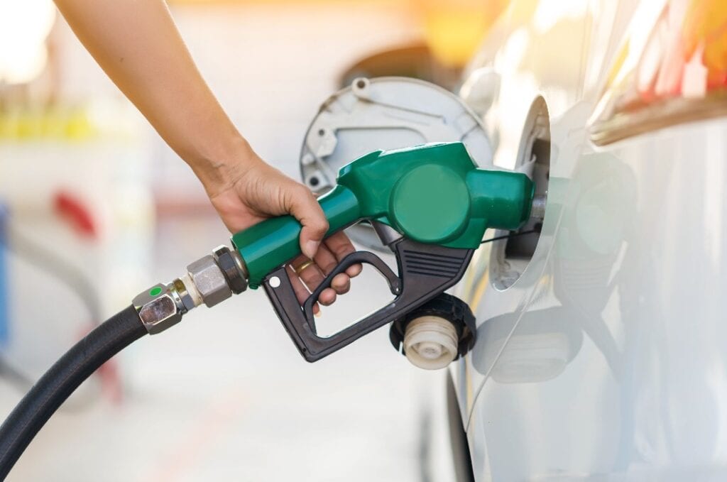 Mann beim Auffüllen von Öl und Gas an einer Tankstelle - ref